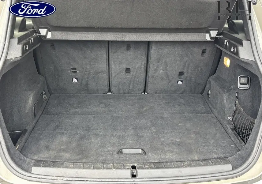 Coffre ouvert d’un BMW Série 2 Active Tourer 216dA 2015, intérieur tissu anthracite avec filet de rangement côté droit.