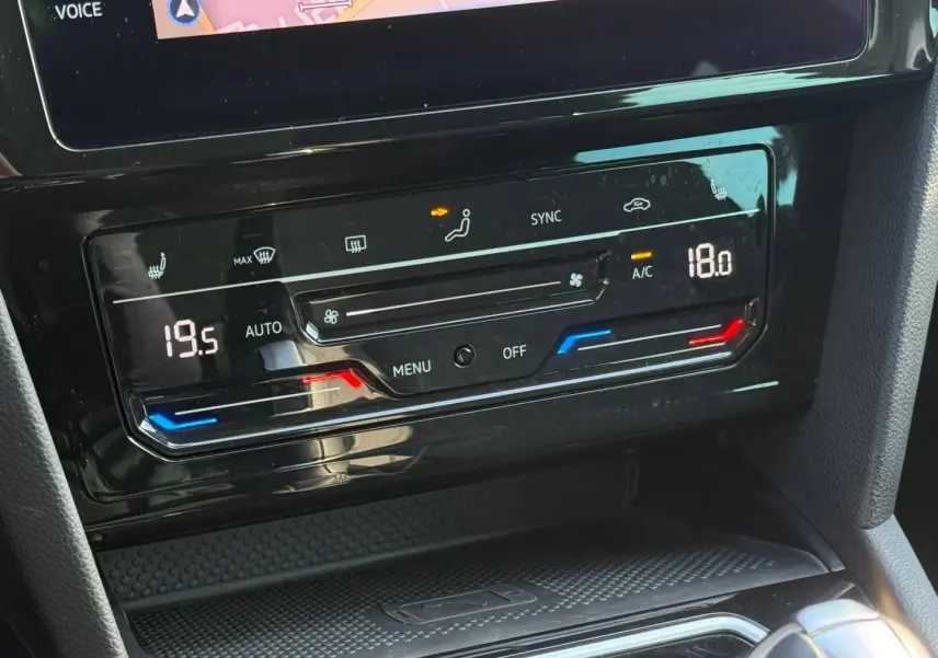 Gros plan sur la console centrale de la Volkswagen Passat SW 2023, montrant l'écran tactile et les commandes de climatisation digitale.