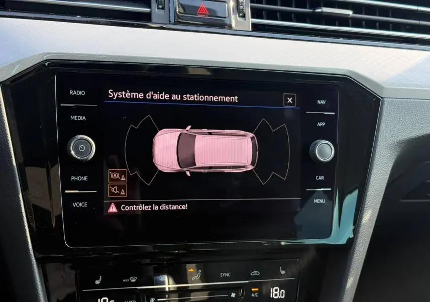 Écran tactile central affichant l’aide au stationnement dans l’habitacle noir de la Volkswagen Passat SW 2023.