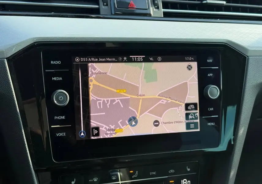 Vue rapprochée de l'écran tactile central du système de navigation de la Volkswagen Passat SW 2023, avec commandes autour.