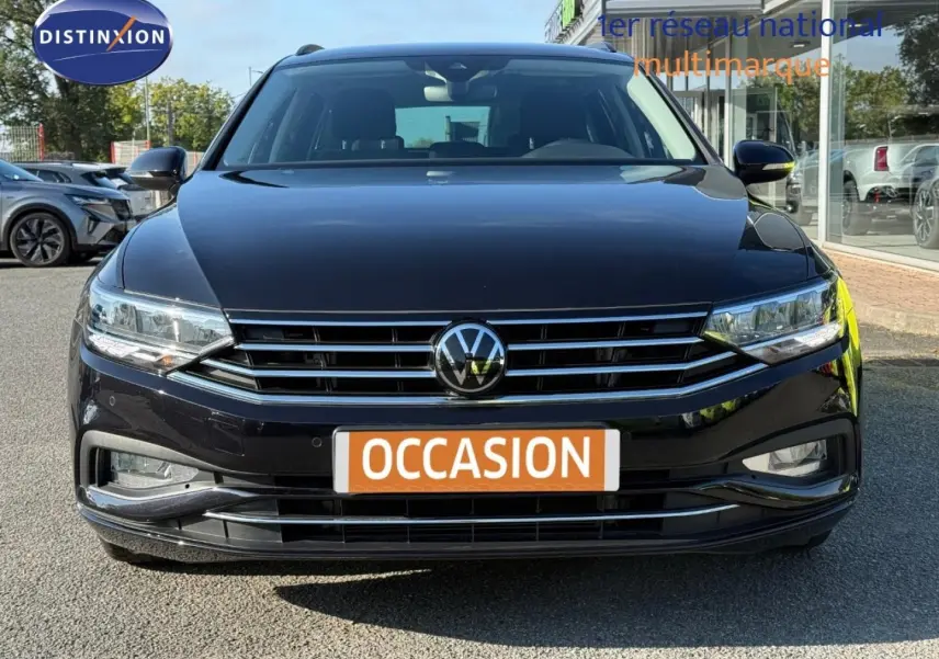 Vue frontale d'une Volkswagen Passat SW noire intense nacrée avec calandre chromée et feux LED, en extérieur.