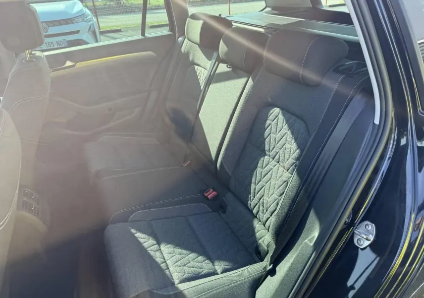 Vue côté droit de la banquette arrière en tissu noir avec surpiqûres blanches dans une Volkswagen Passat SW 2023.