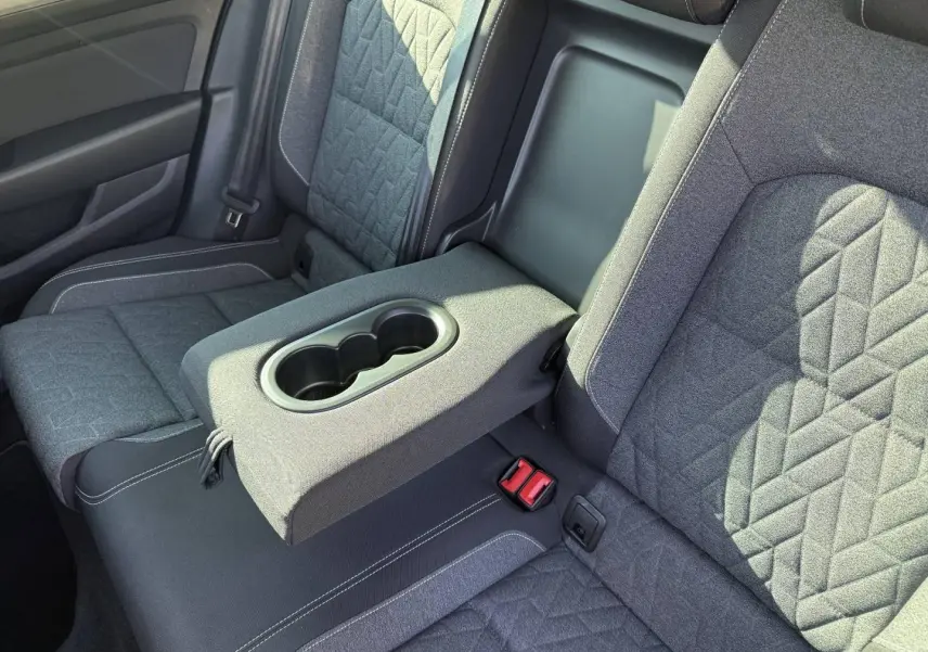 Vue rapprochée de la banquette arrière grise de la Volkswagen Passat SW 2023 avec accoudoir central et porte-gobelets intégrés.