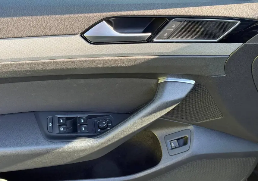 Vue rapprochée de la porte avant gauche de la Volkswagen Passat SW 2023, avec commandes vitres et verrouillage.