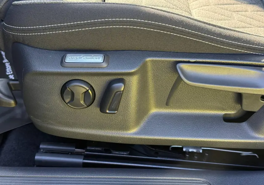 Détail côté gauche du siège avant noir avec commandes de réglage ErgoComfort sur Volkswagen Passat SW 2023.