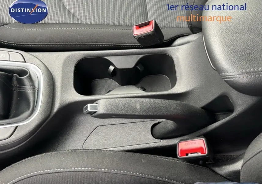 Gros plan intérieur sur la console centrale noire de la Hyundai i30 2023 avec frein à main et porte-gobelets visibles.