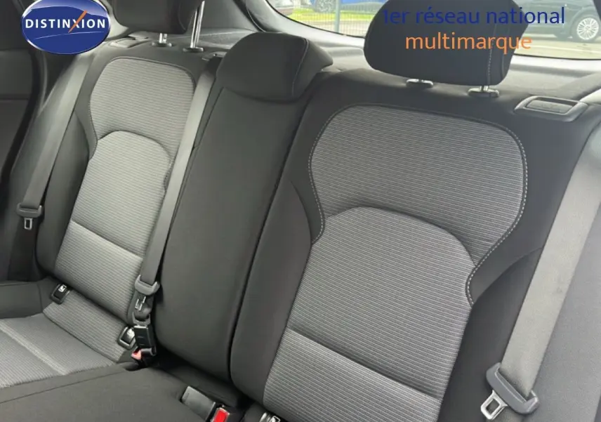 Vue intérieure montrant les sièges arrière en tissu gris et noir de la Hyundai i30 2023, avec ceintures de sécurité visibles.