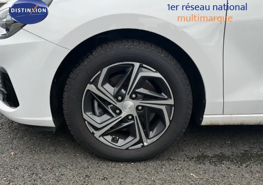 Gros plan sur la roue avant droite d'une Hyundai i30 blanche nacrée avec jante alliage bi-ton 16 pouces.
