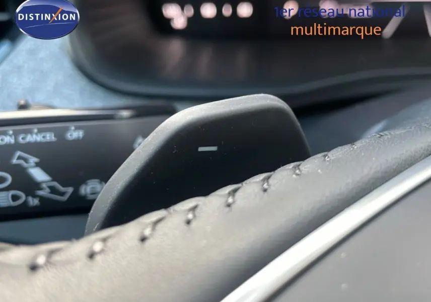 Gros plan sur la palette de changement de vitesse au volant d’un Skoda Kamiq gris argent, intérieur cuir noir.