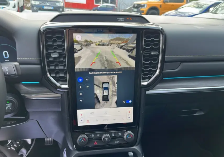 Vue intérieure du tableau de bord du Ford Ranger gris iconic 2026, avec écran tactile central affichant caméra 360° et aides au stationnement.