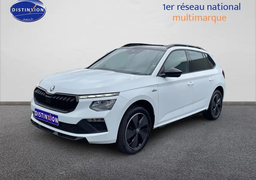 Vue 3/4 avant droite d'un Skoda Kamiq blanc nacré avec toit panoramique et jantes noires distinctives.