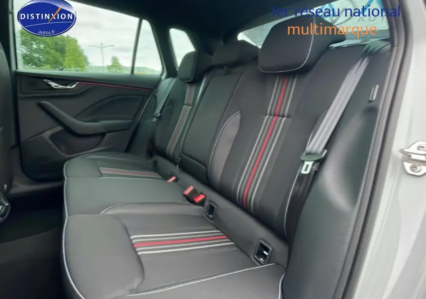 Vue intérieure côté droit sur la banquette arrière noire avec surpiqûres blanches et bandes rouges du Skoda Kamiq blanc nacré.