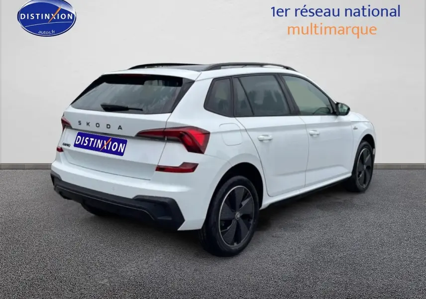 Vue 3/4 arrière droite d'un Skoda Kamiq blanc nacré avec jantes noires et toit panoramique en verre.