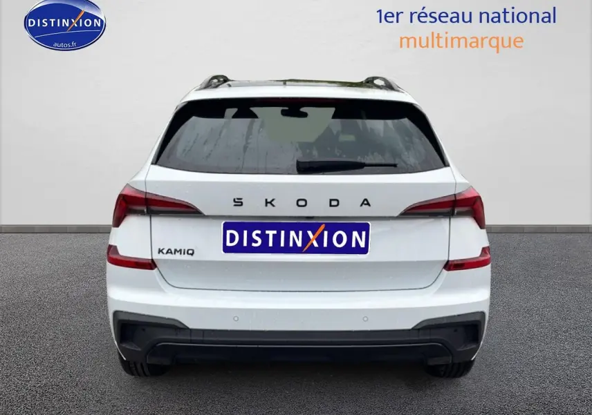 Vue arrière d'un Skoda Kamiq blanc nacré avec feux LED et diffuseur noir, immatriculé Distinxion.
