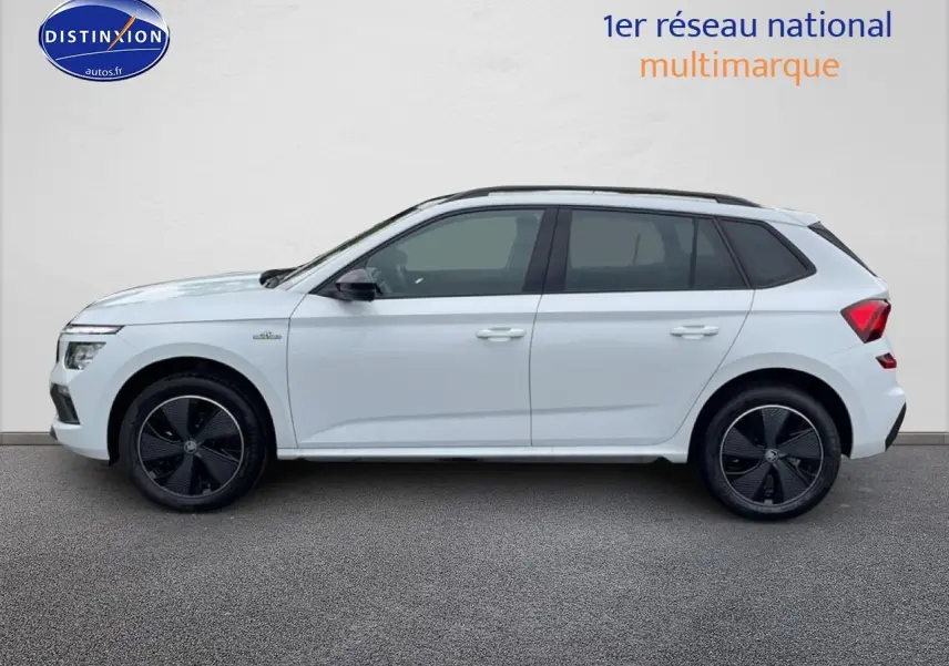 Profil droit d'un Skoda Kamiq blanc nacré avec jantes noires et toit panoramique en verre visible.