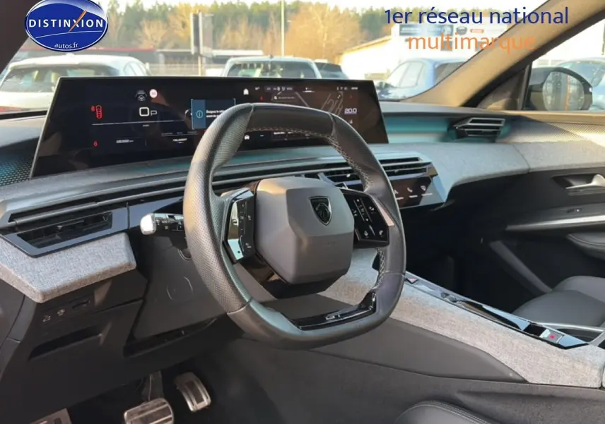 Intérieur avant du Peugeot 3008 gris 2025, volant cuir multifonction et grand écran tactile panoramique.