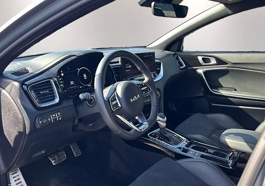 Intérieur avant du KIA Xceed gris 2024, vue côté conducteur, volant cuir multifonction et console centrale brillante.