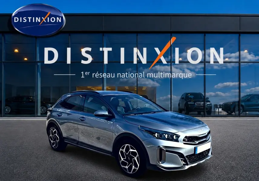 KIA Xceed gris 3/4 avant droit, jantes alu distinctives, devant vitrine du réseau Distinxion.