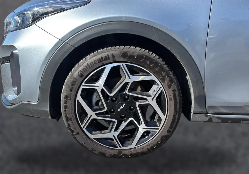 Gros plan sur la roue avant gauche du KIA Xceed gris 2024 avec jante alliage noire et argentée au design géométrique.