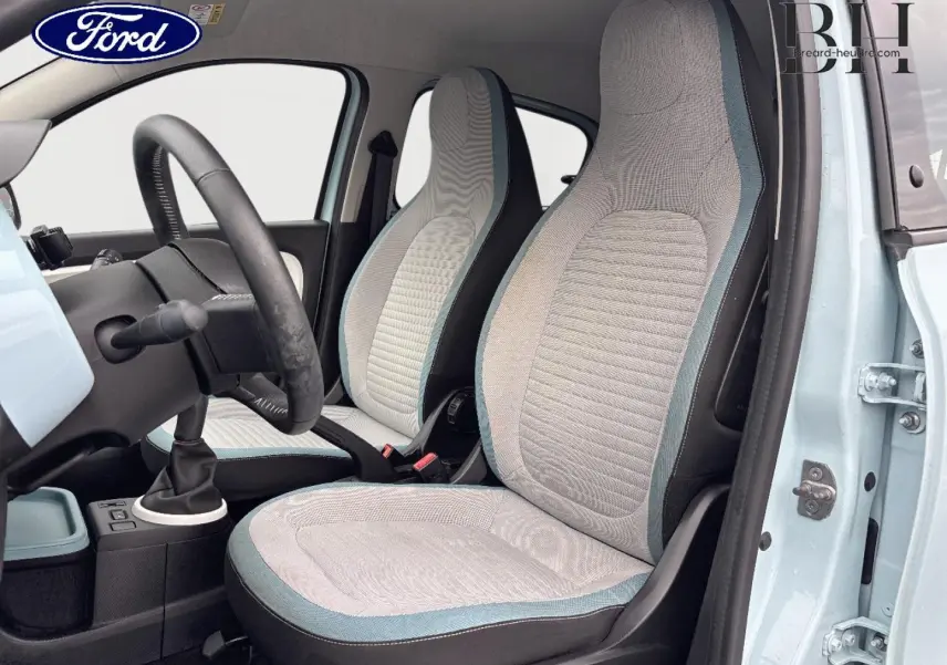 Vue intérieure côté conducteur de la Renault Twingo Bleu Dragée 2014, sièges tissu gris avec surpiqûres bleues.