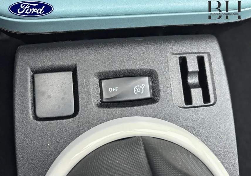 Gros plan sur les commandes du régulateur de vitesse et les aérateurs, intérieur noir de la Renault Twingo Bleu Dragée 2014.