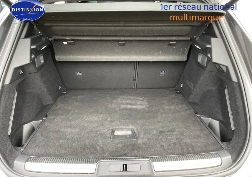 Coffre ouvert du DS7 Crossback gris platinium, vue de l'arrière montrant un espace de chargement spacieux et bien fini.