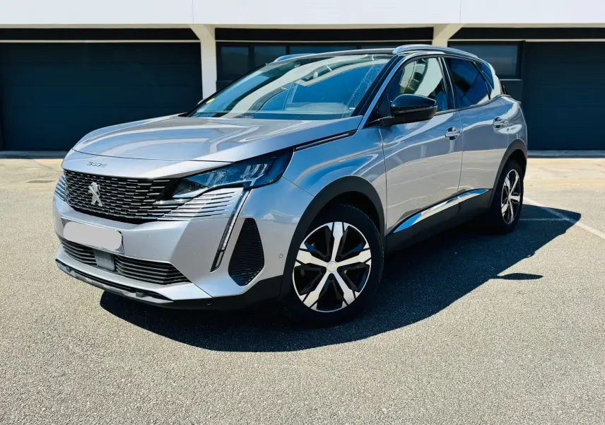 Peugeot 3008 gris Artens vue 3/4 avant droit avec toit noir et jantes bi-tons sur parking ensoleillé.