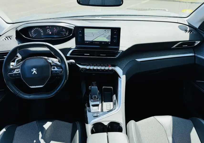 Vue intérieure avant du Peugeot 3008 2021, tableau de bord moderne avec écran tactile et volant compact noir.
