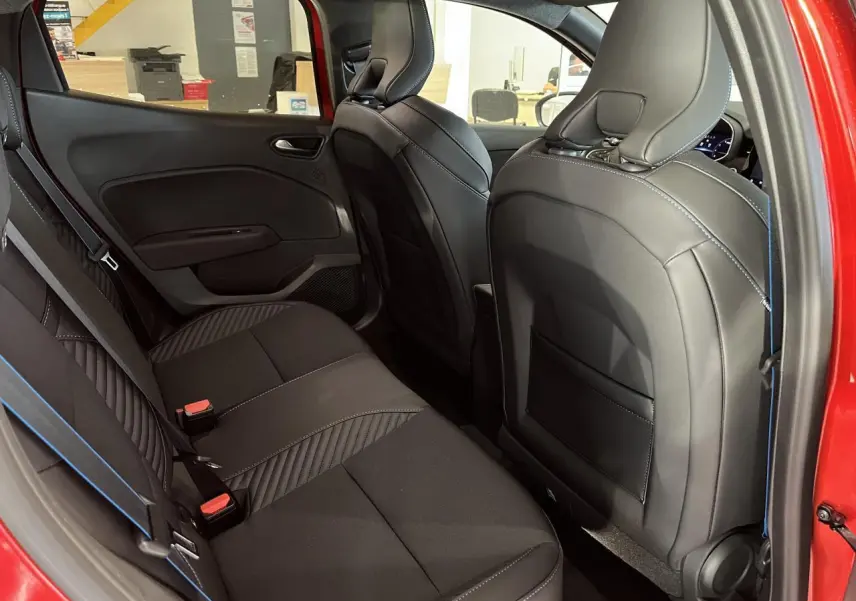 Vue côté gauche de l'habitacle arrière de la Renault Clio 2024 rouge, sièges tissu noir avec surpiqûres bleues esprit Alpine.