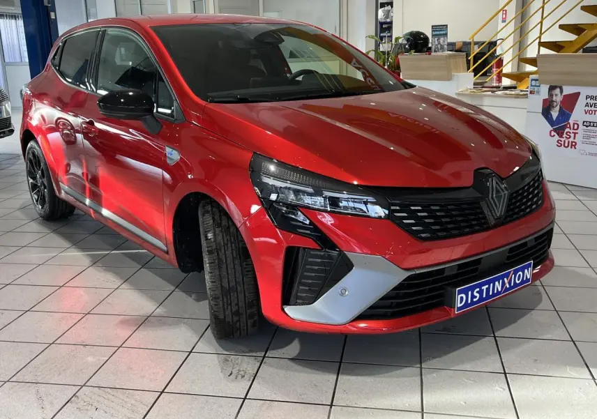 Renault Clio 2024 rouge vue 3/4 avant avec calandre noire et détails gris schiste satin.