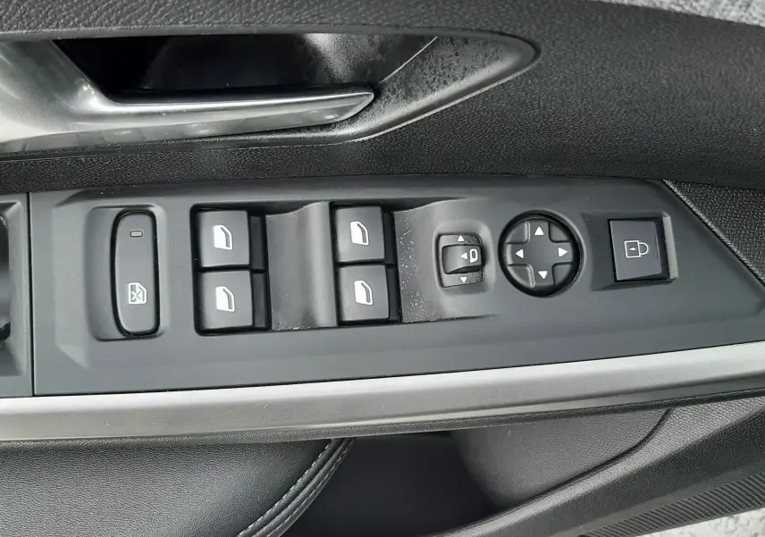 Vue rapprochée des commandes de lève-vitres et rétroviseurs sur la porte côté gauche d’un Peugeot 3008 bleu Ingara.