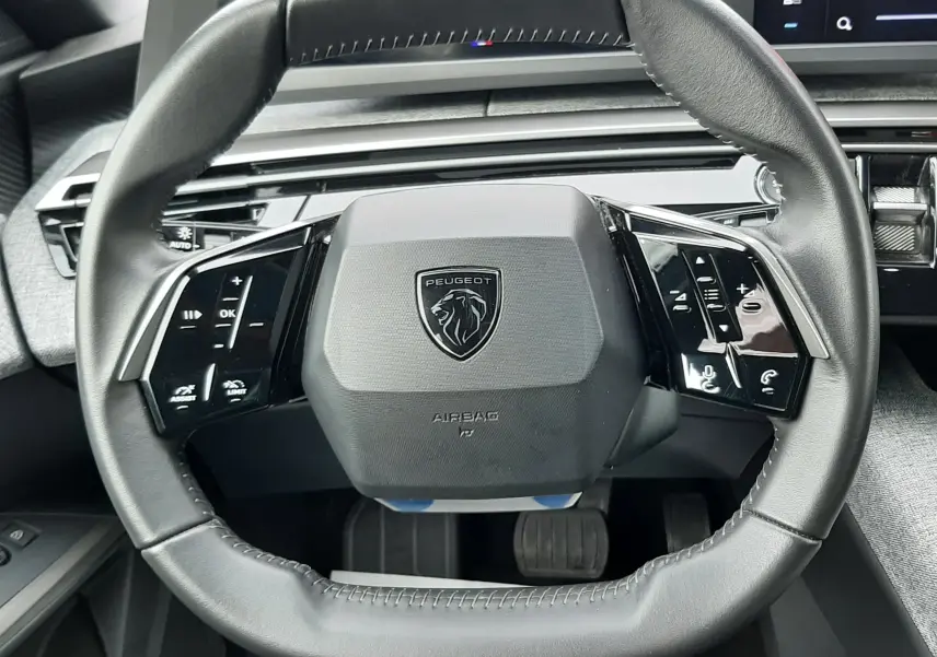 Vue rapprochée du volant cuir noir du Peugeot 3008 III Hybrid 145 Allure avec commandes intégrées et tableau de bord numérique.