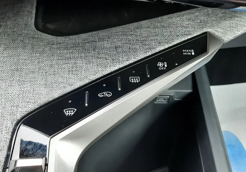 Gros plan sur la console centrale du Peugeot 3008 III Hybrid 145 Allure, montrant les commandes de climatisation et mode de conduite.