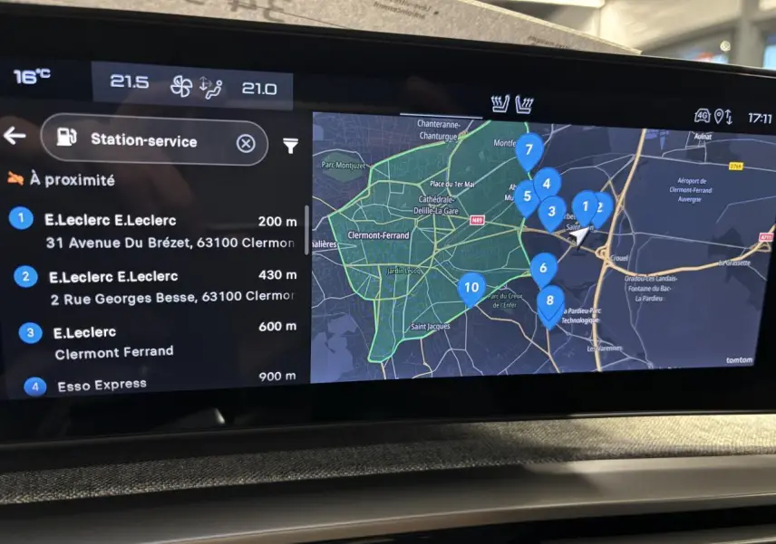 Vue intérieure de l'écran tactile du Peugeot 3008 2025 affichant une carte de navigation avec stations-service à proximité.