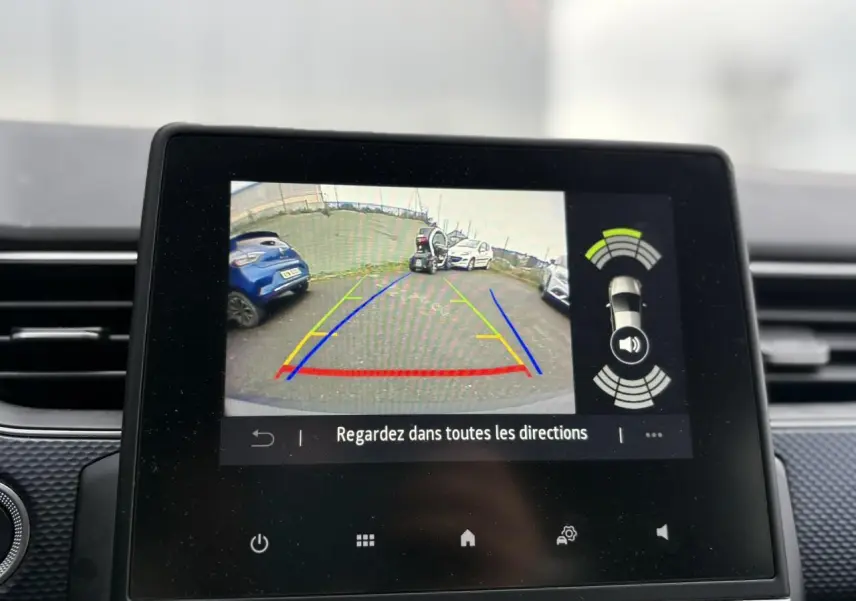 Écran tactile intérieur montrant la caméra de recul du Renault Arkana bleu Zanzibar en stationnement.