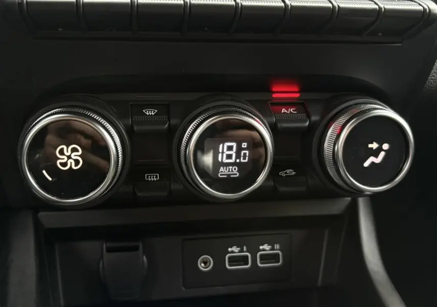 Gros plan sur les commandes de climatisation automatique du Renault Arkana 2025, avec affichage digital à 18°C.