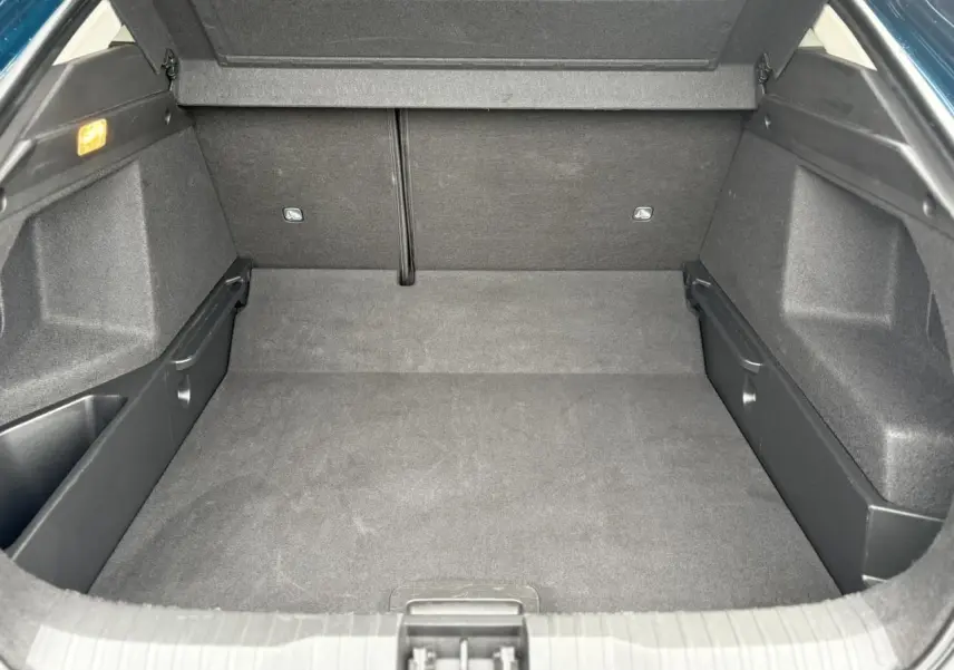 Coffre ouvert vu de face, intérieur spacieux et tapis noir du Renault Arkana TCE 140 EDC MHEV Bleu Zanzibar.