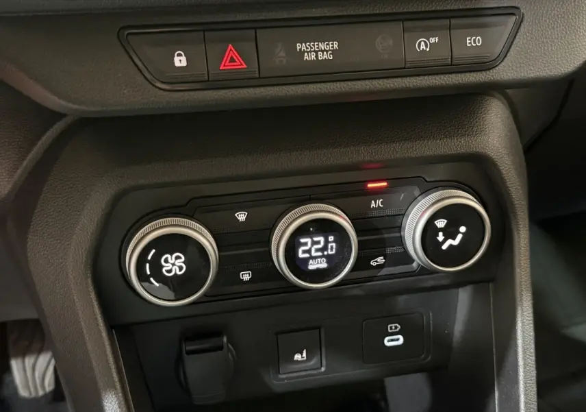 Gros plan sur la console centrale de la Dacia Sandero 2024, montrant les commandes de climatisation automatique à 22,8°C.