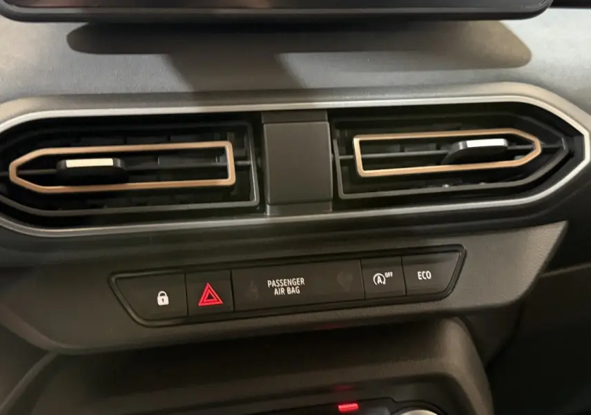 Détail du tableau de bord central de la Dacia Sandero Extreme+ 2024, montrant les aérateurs et les boutons de sécurité.