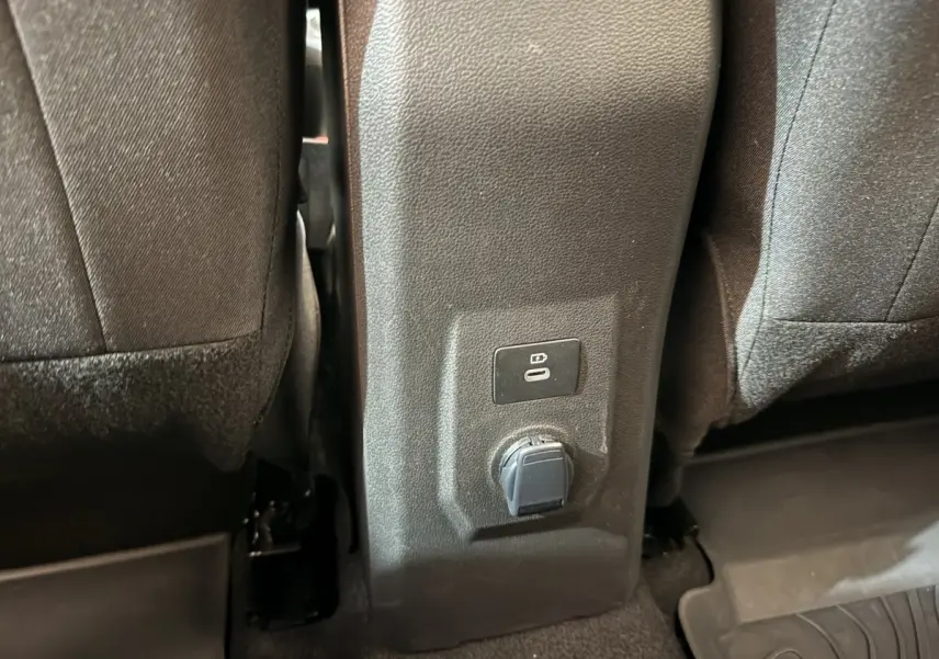 Prise USB et prise 12V entre les sièges arrière d'une Dacia Sandero Extreme+ TCe 110 verte, vue intérieure rapprochée.