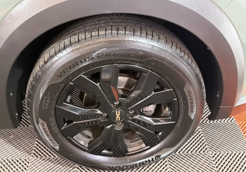 Gros plan sur la roue avant droite noire à jante alliage du Dacia Sandero Extreme+ vert 2024.