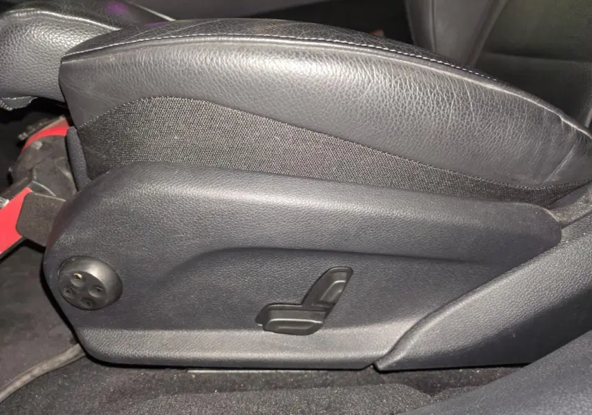 Détail du réglage électrique du siège avant en cuir noir dans un Mercedes Classe E Break gris 2020 AMG Line.
