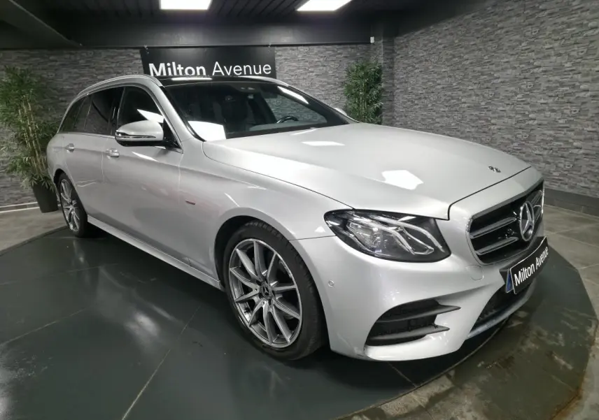 Mercedes Classe E Break gris métallisé en 3/4 avant droit avec jantes AMG 19 pouces et vitres teintées.