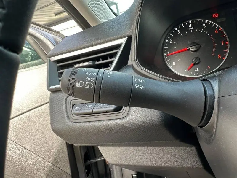 Détail du commodo d’éclairage côté gauche du tableau de bord d’une Renault Clio gris 2023, avec compte-tours visible.