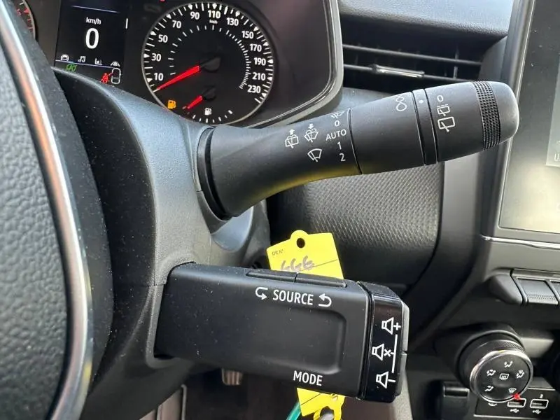 Gros plan sur la commande des essuie-glaces et du régulateur audio dans le tableau de bord gris d'une Renault Clio 2023.