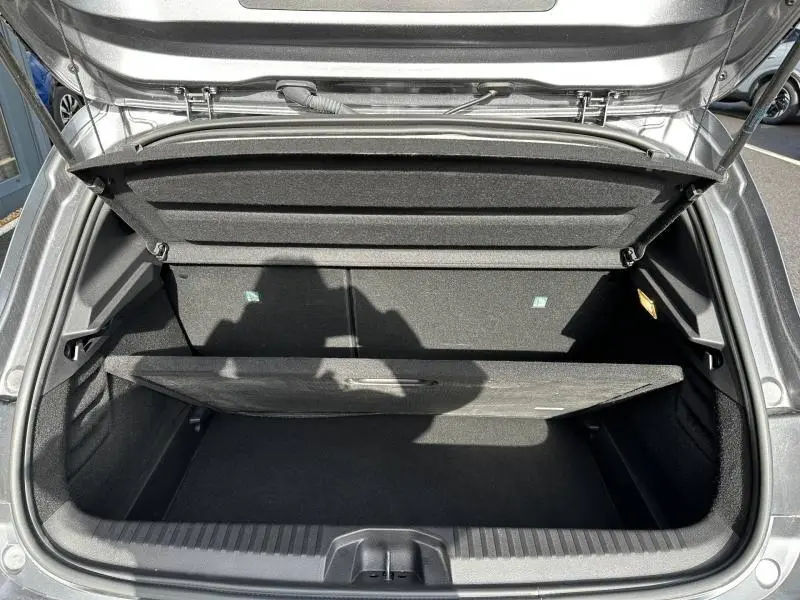 Coffre ouvert vu de dessus d'une Renault Clio gris 2023, montrant le compartiment de rangement et la tablette arrière.