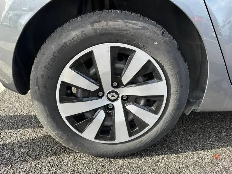 Gros plan sur la roue avant droite d’une Renault Clio gris 2023, mettant en valeur la jante alliage au design moderne.