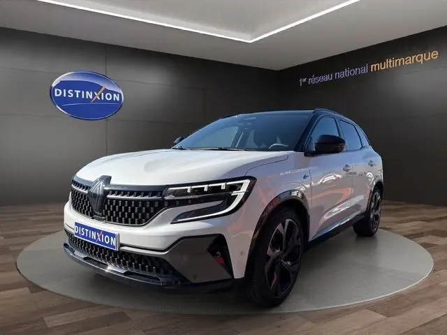 Vue 3/4 avant d’un Renault Austral blanc avec calandre noire et jantes noires dans un showroom.