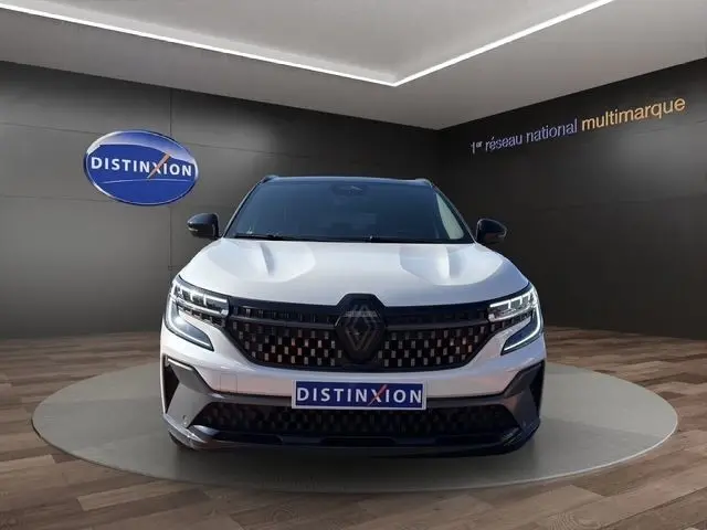 Vue frontale d'un Renault Austral blanc esprit Alpine avec calandre noire et logo central distinctif en showroom.
