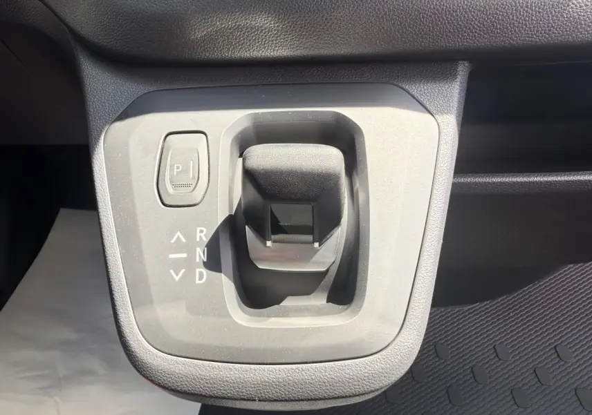 Gros plan sur la commande de boîte automatique noire du Renault Trafic Fourgon blanc, vue intérieure centrale.